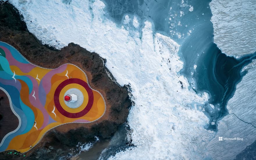 Aerial view of the frozen sea and the lighthouse on the cliff, Dalian Boxiawan Park, Liaoning Province, China