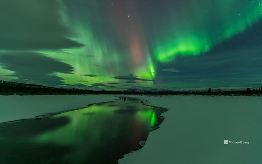 Northern Lights over open water in winter near Whitehorse, Yukon